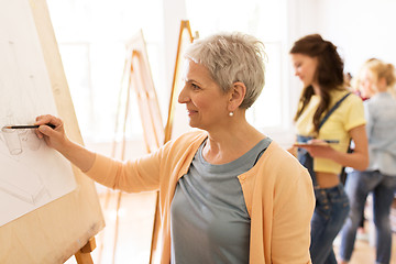 Image showing woman artist with pencil drawing at art school