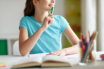 Image showing happy girl with book and notebook dreaming at home