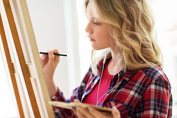 Image showing student girl with easel painting at art school