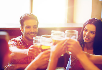 Image showing happy friends drinking beer at bar or pub