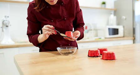 Image showing chef decorating mirror glaze cakes at pastry shop