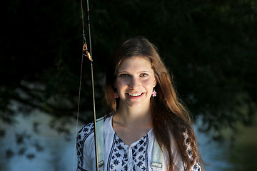 Image showing Young woman with summer sprouts and dungarees while fishing