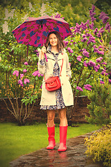 Image showing European woman dressed up in a raincoat with an umbrella in the 