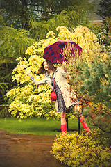 Image showing funny beautiful woman with an umbrella in the rain