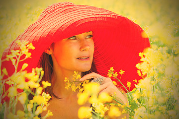 Image showing woman in a red hat on a sunny day amidst wildflowers. portrait, 