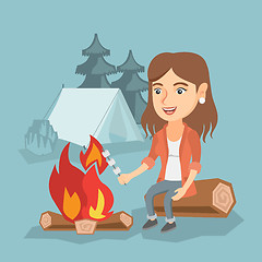 Image showing Caucasian girl roasting marshmallow over campfire.