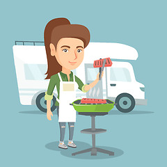 Image showing Woman barbecuing meat in front of camper van.