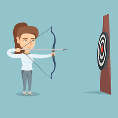 Image showing Sportswoman aiming with a bow and arrow at target.