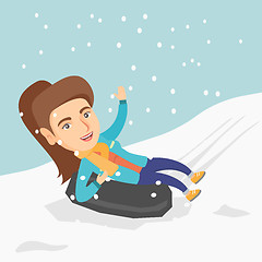 Image showing Girl sledding on snow rubber tube in the mountains