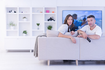 Image showing Young couple on the sofa watching television