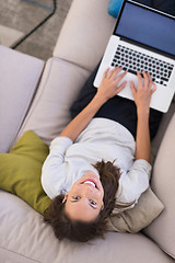 Image showing Young woman using laptop at home top view