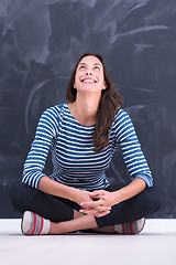 Image showing woman sitting in front of chalk drawing board