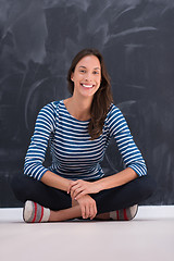 Image showing woman sitting in front of chalk drawing board