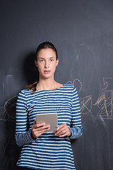 Image showing woman using tablet  in front of chalk drawing board