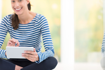 Image showing young women using tablet computer on the floor