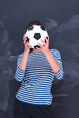 Image showing woman holding a soccer ball in front of chalk drawing board