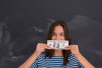 Image showing woman holding a banknote in front of chalk drawing board