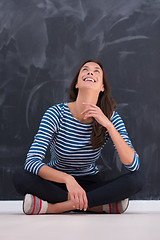 Image showing woman sitting in front of chalk drawing board