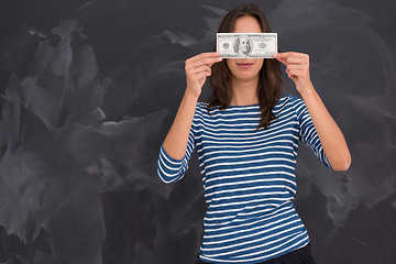 Image showing woman holding a banknote in front of chalk drawing board