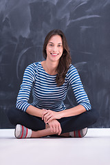 Image showing woman sitting in front of chalk drawing board