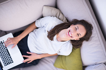 Image showing Young woman using laptop at home top view