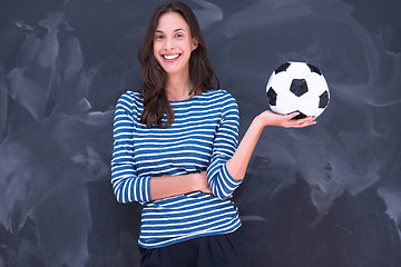 Image showing woman holding a soccer ball in front of chalk drawing board