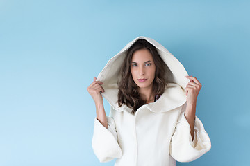 Image showing woman in a white coat with hood isolated on blue background