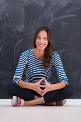 Image showing woman sitting in front of chalk drawing board