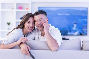 Image showing Young couple on the sofa watching television