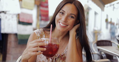 Image showing Smiling woman posing with drink in cafe