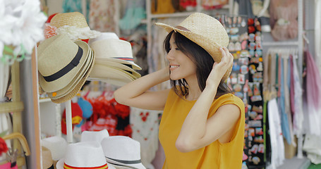 Image showing Charming model trying on hats in shop