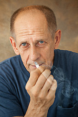 Image showing Worried mature man sitting at studio