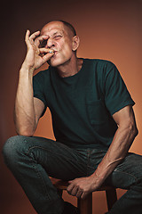 Image showing Worried mature man sitting at studio