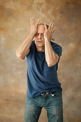 Image showing Worried mature man touching his head.