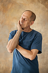 Image showing Worried mature man touching his head.