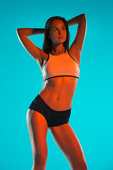 Image showing Muscular young woman athlete posing at studio