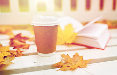 Image showing coffee drink in paper cup on bench at autumn park