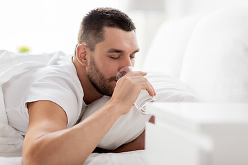 Image showing man in bed with glass of water drinking at home