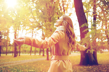 Image showing beautiful happy young woman walking in autumn park