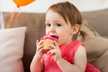 Image showing happy baby girl eating cupcake on birthday party