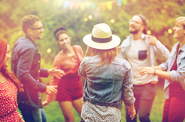 Image showing happy friends dancing at summer party in garden