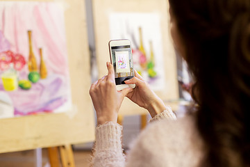 Image showing woman with painting on smartphone at art school