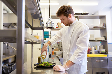 Image showing happy male chef cooking food at restaurant kitchen