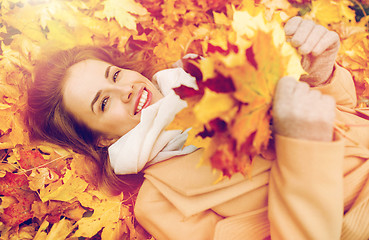 Image showing beautiful happy woman lying on autumn leaves