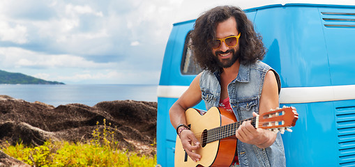 Image showing hippie man playing guitar at minivan car on island