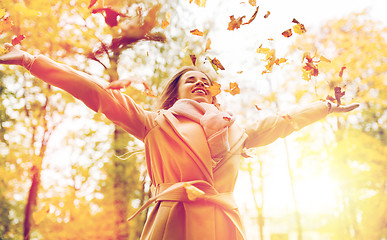 Image showing happy woman having fun with leaves in autumn park