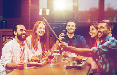 Image showing friends taking selfie by smartphone at restaurant