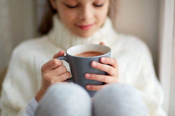 Image showing girl with cacao mug looking at home window