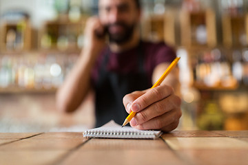 Image showing bartender with notebook and pencil at bar