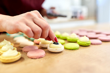 Image showing chef decorating macarons shells at pastry shop